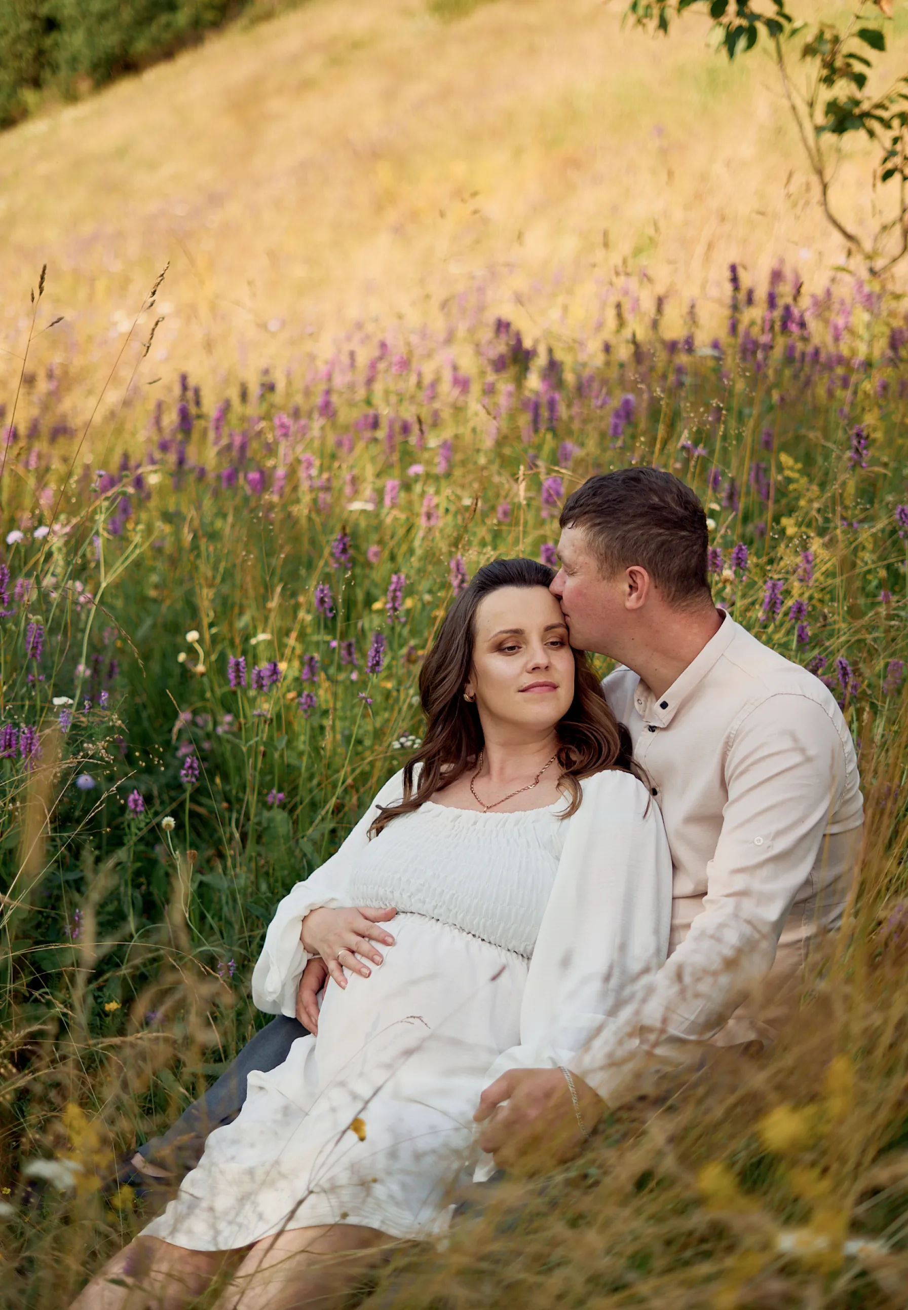 Maternity photoshoot in wildflower meadow at golden hour